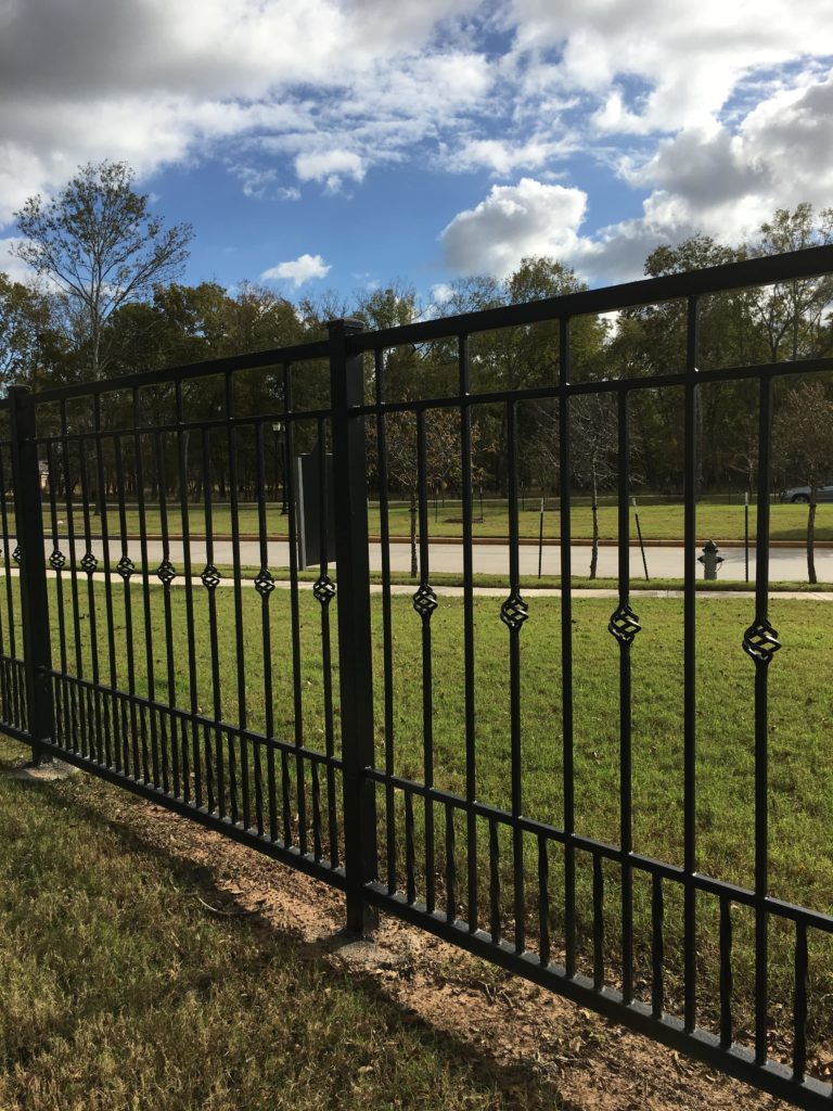 wrought iron fence on the side of the road